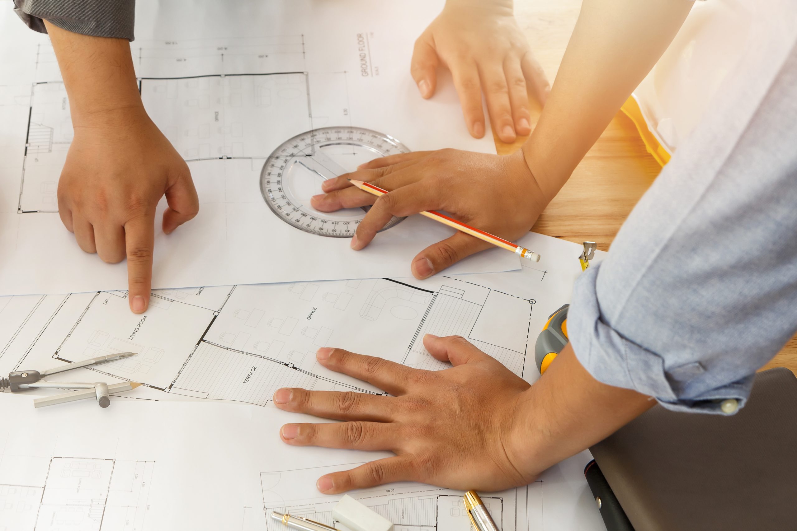 Architect or engineer working on blueprint, architectural concept. Engineer discussing with Architect team meeting and discussing project plan.Engineer discussing with Architect about project